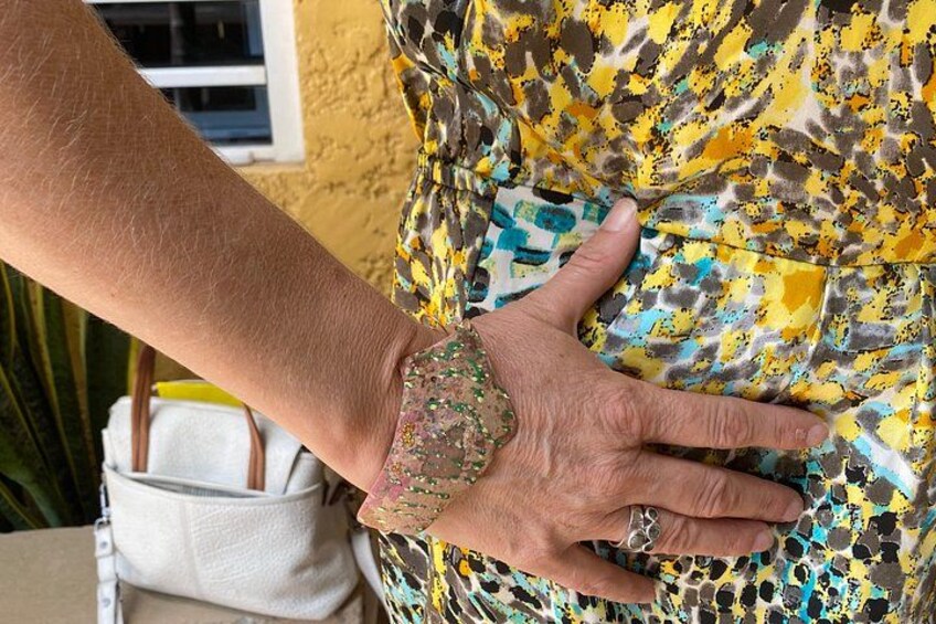 A hand on a patterned fabric, a white bag, and a window. 3