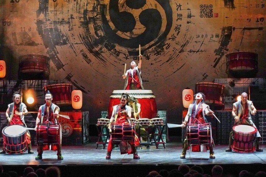 A traditional Japanese drum performance with performers in red and white attire. 1