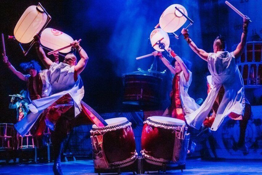 A group performing a traditional dance with drums and fans. 3