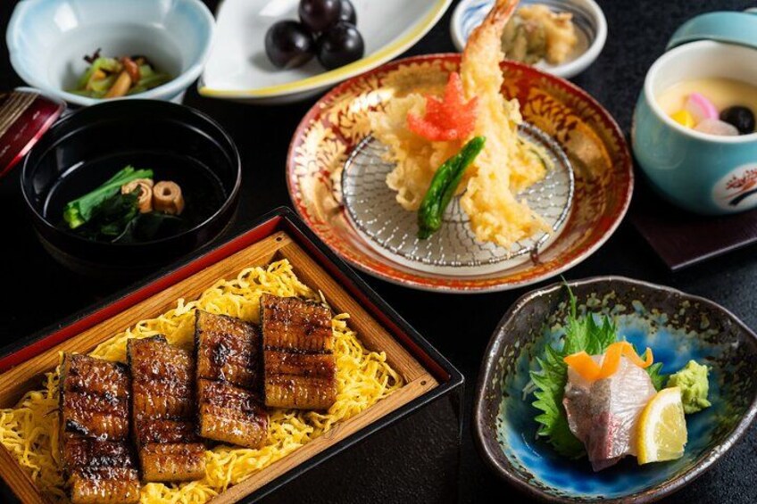 A variety of Japanese dishes including grilled meat, tempura, and sashimi. 2