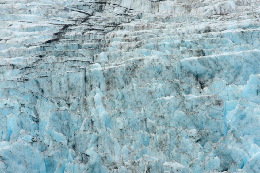 A glacier with visible crevasses and ice formations. 2