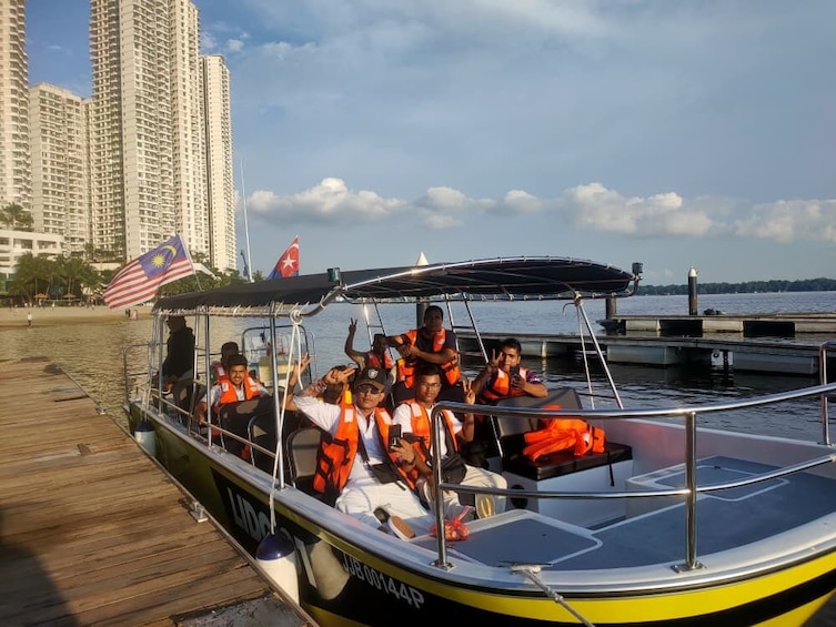 A boat with passengers wearing life jackets, docked at a pier with a city skyline in the background. 5