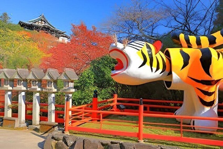 A large tiger statue, a traditional Japanese building, and autumn-colored trees. 2
