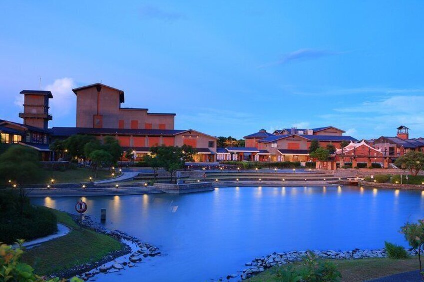 A lakeside resort with modern architecture, a calm water body, and a clear sky. 2
