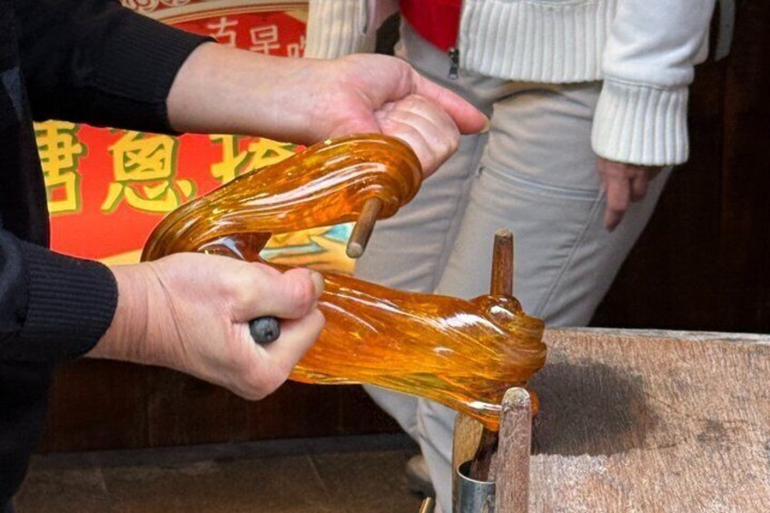 A person holding a glass object, possibly a bottle, with a wooden handle. 3