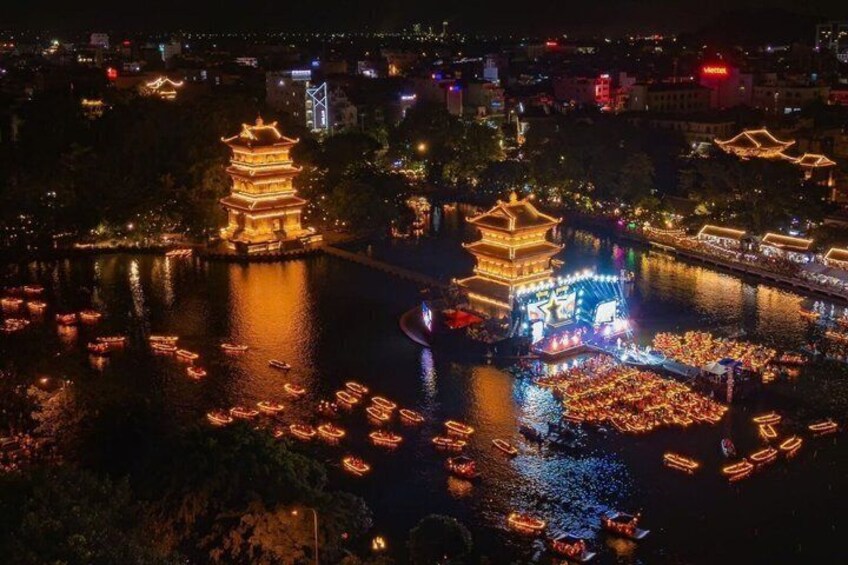 A night view of a river with illuminated pagodas and boats. 4