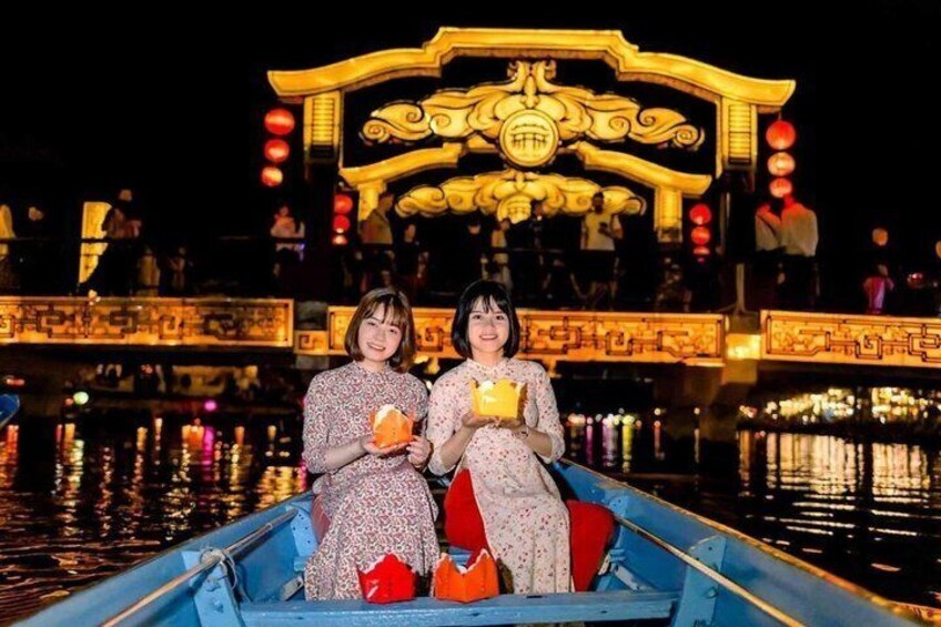 Two people in a boat with a traditional ornate bridge in the background. 5