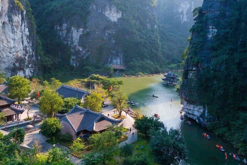A traditional village with buildings and a river. 1