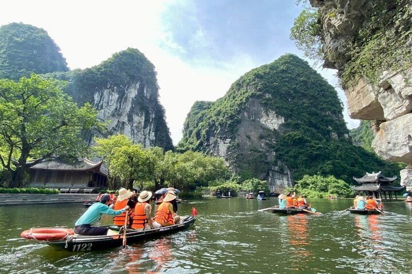 A group of people in a boat on a river, surrounded by rocky cliffs and trees. 3