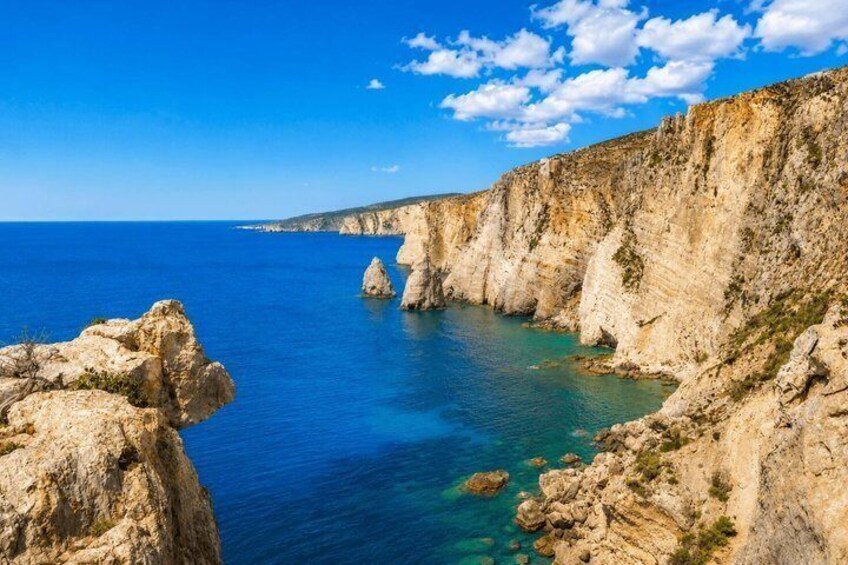 A coastal landscape with cliffs and clear blue sea. 2