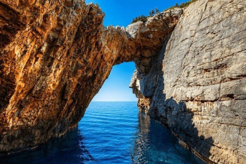 A coastal rock formation with a natural arch over the sea. 3