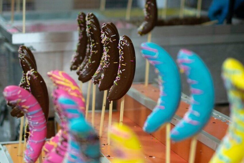 Chocolate-covered confections on sticks, some with colorful icing. 4