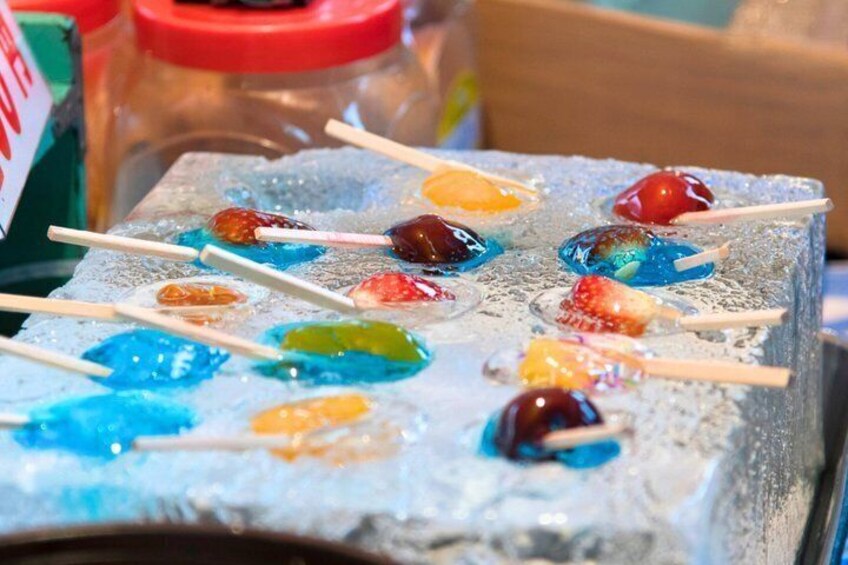 Colorful lollipops on sticks in a glass container. 5