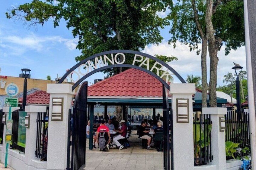 A gated entrance with 'DOMINO PARK' signage, a covered seating area, and a paved walkway. 2