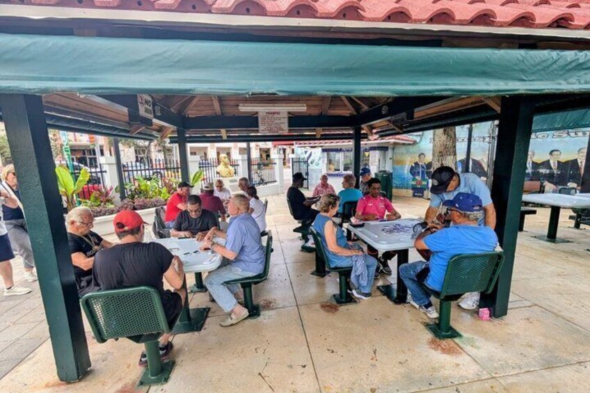 People seated at tables under a covered pavilion. 5