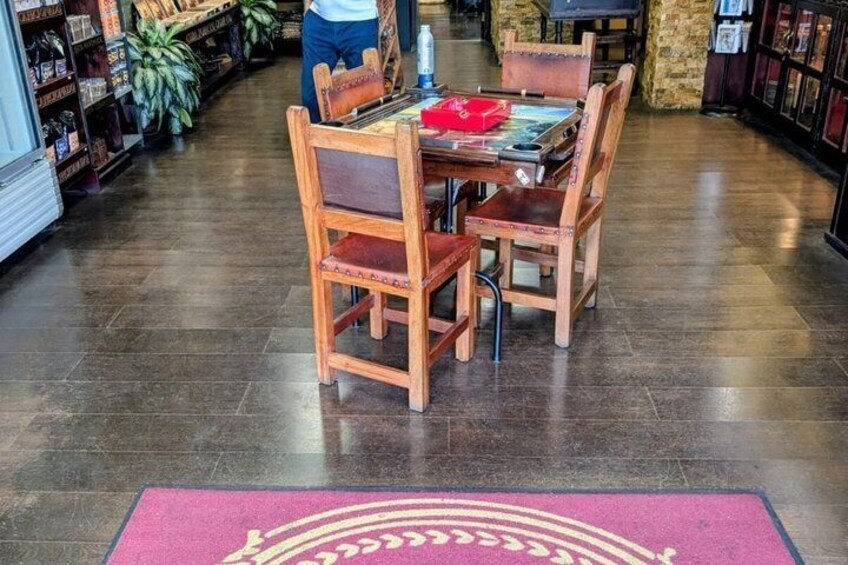 A wooden table with chairs in a bookstore, surrounded by shelves with books and plants. 4