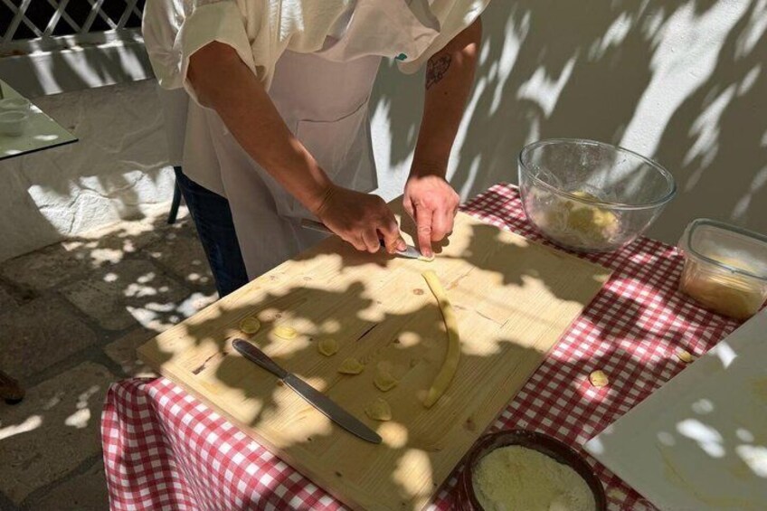 A person preparing food outdoors on a checkered tablecloth. 4