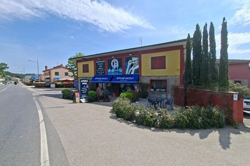 A street with a building that has a sign for a restaurant and a blue awning. 5