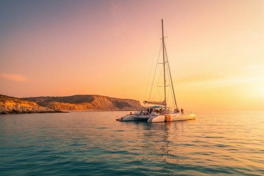 A sailboat on calm waters with a hilly coastline in the background. 1