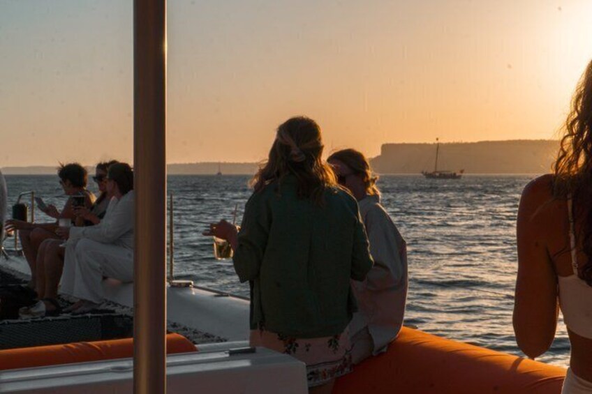 A sunset over the ocean with a boat and people on it. 5