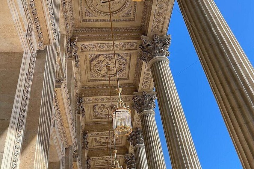 A classical building's interior with ornate columns and a detailed ceiling. 4