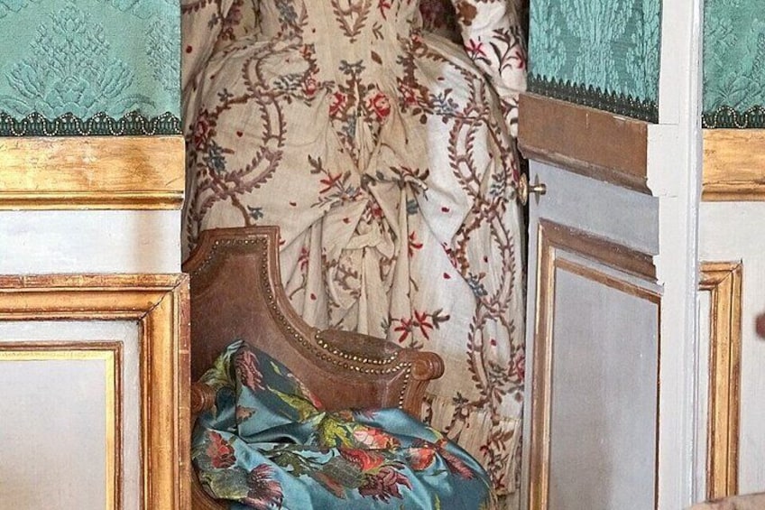 A bed with a floral patterned bedspread and a wooden headboard. 2