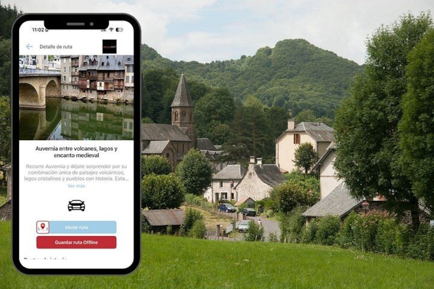 A smartphone displaying a travel route with a scenic view of a town surrounded by greenery and hills. 2