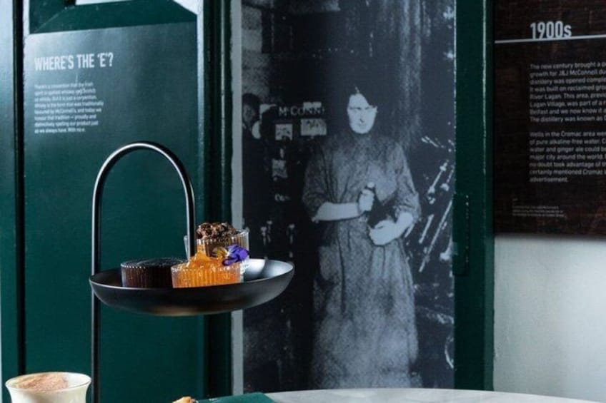 A black metal tray with desserts and a vintage poster in the background. 2