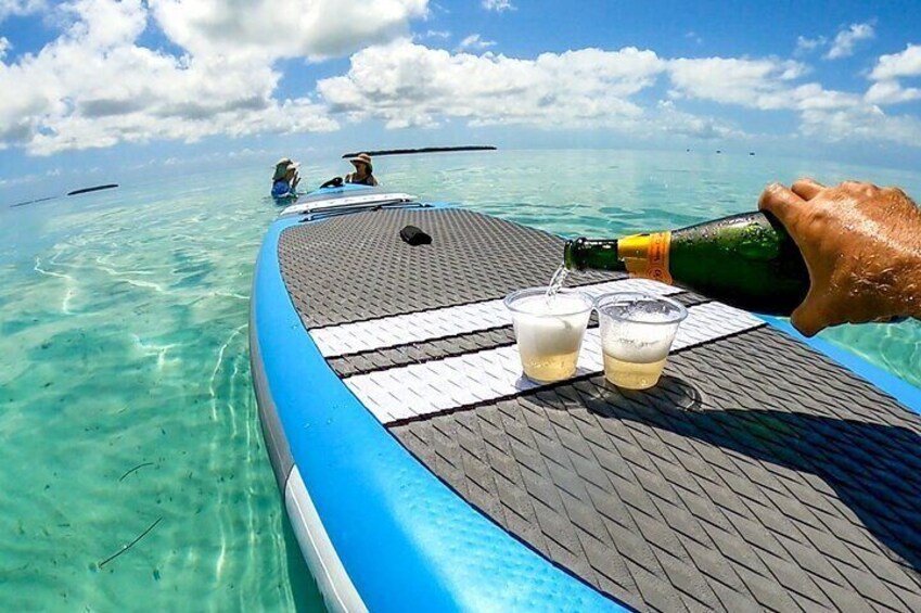A boat with a table, two glasses, and a bottle being poured into one glass. 5