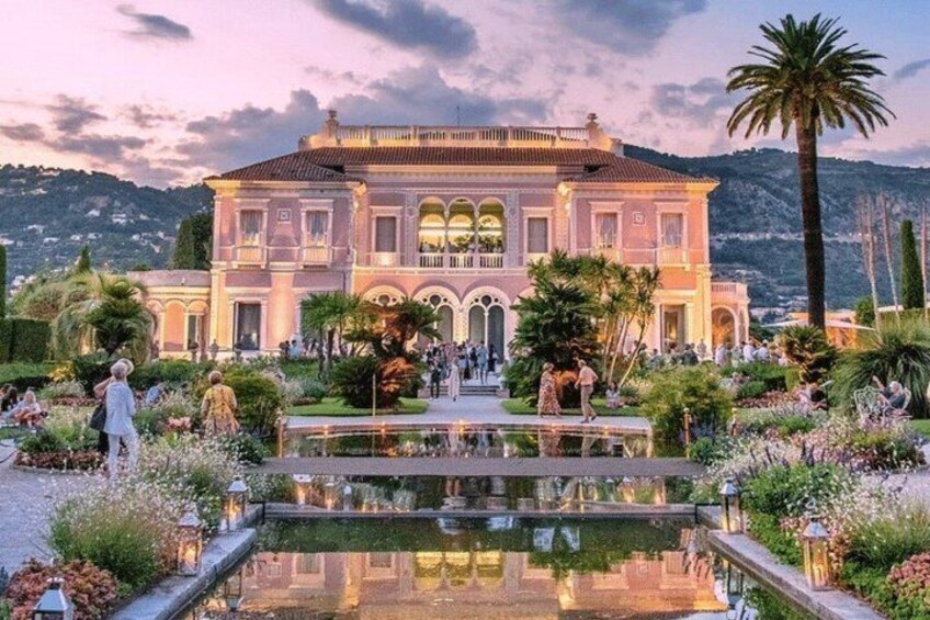 A grand building with a reflective pool and lush gardens. 1