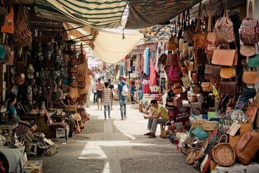 A market with various bags and accessories displayed on racks. 3