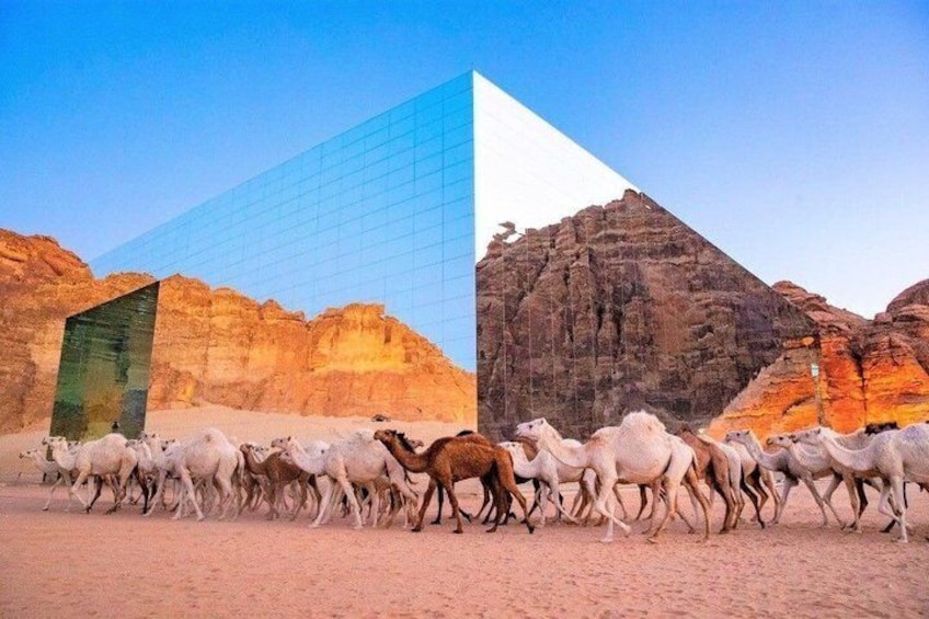 A desert landscape with a modern building and a pyramid. 5