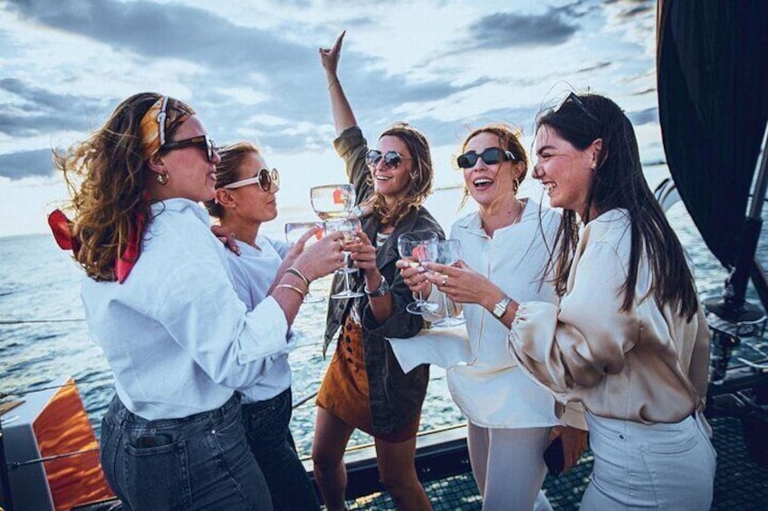A group of people on a boat, toasting with drinks. 5