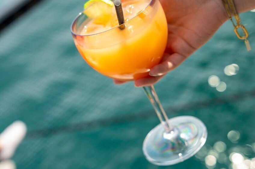 A hand holding a cocktail glass with a lime wedge. 3
