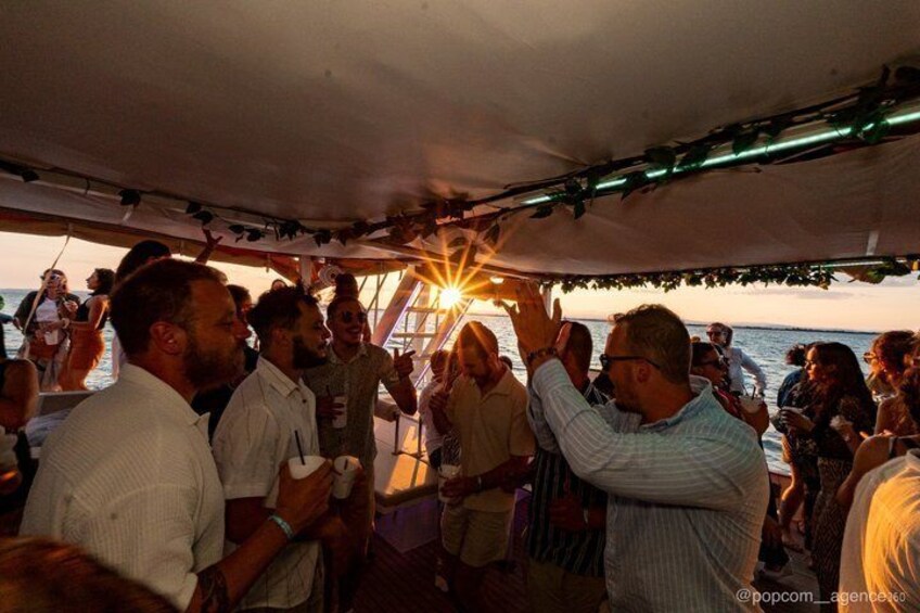 A group of people on a boat at sunset. 1