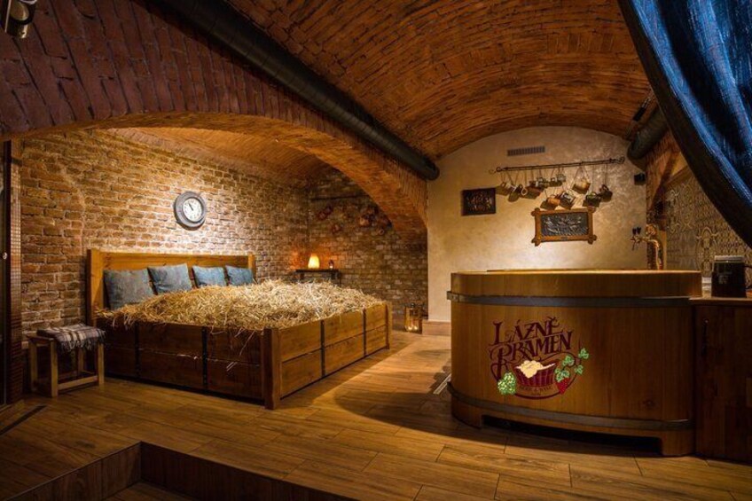 A rustic room with a bed, a wooden counter, and a clock on the wall. 2