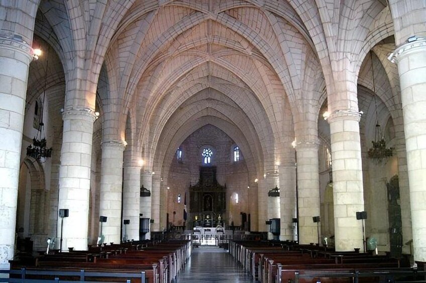 A cathedral interior with high vaulted ceilings, rows of pews, and a central aisle leading to an altar. 3
