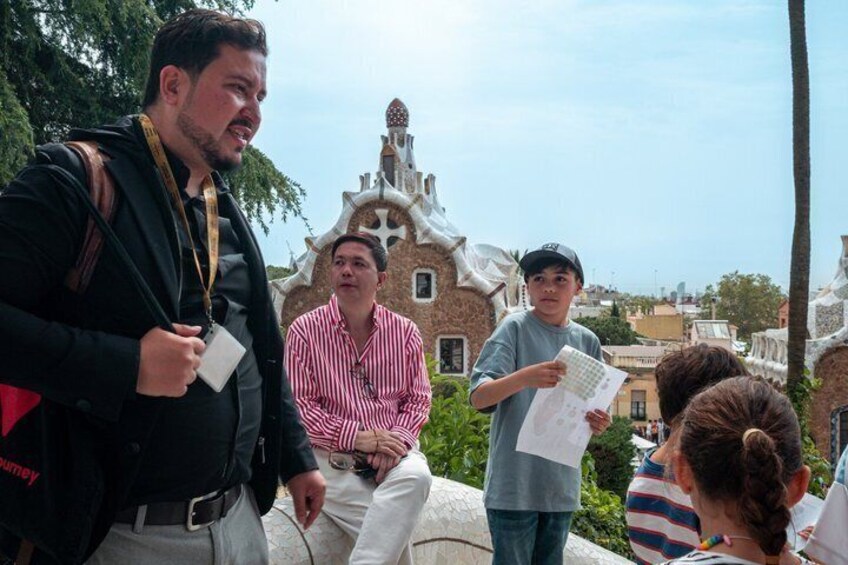 A group of people standing outdoors with a unique building in the background. 3