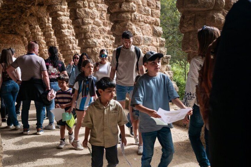 A group of people walking in a rocky outdoor area with stone walls. 1