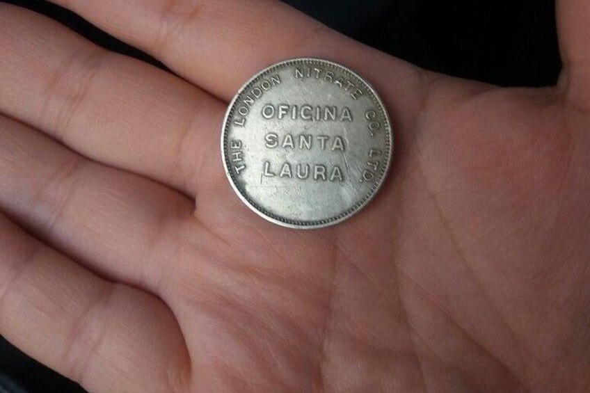 A hand holding a coin with inscriptions. 5