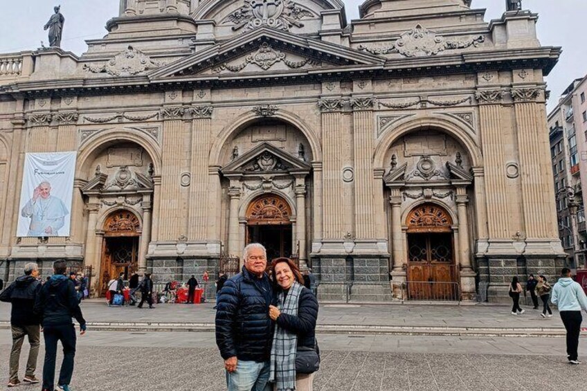 A historic building with ornate architecture, large wooden doors, and a prominent statue on top. 3