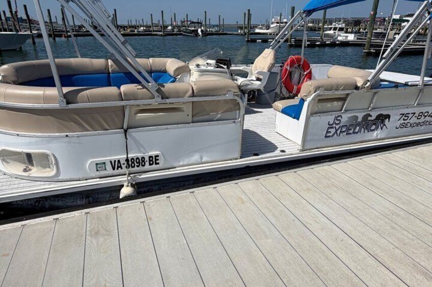 A boat docked at a marina with a blue life preserver and a white license plate. 4