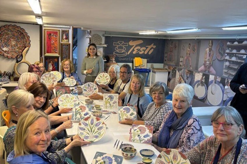 A group of people at a table with ceramic plates and bowls. 1