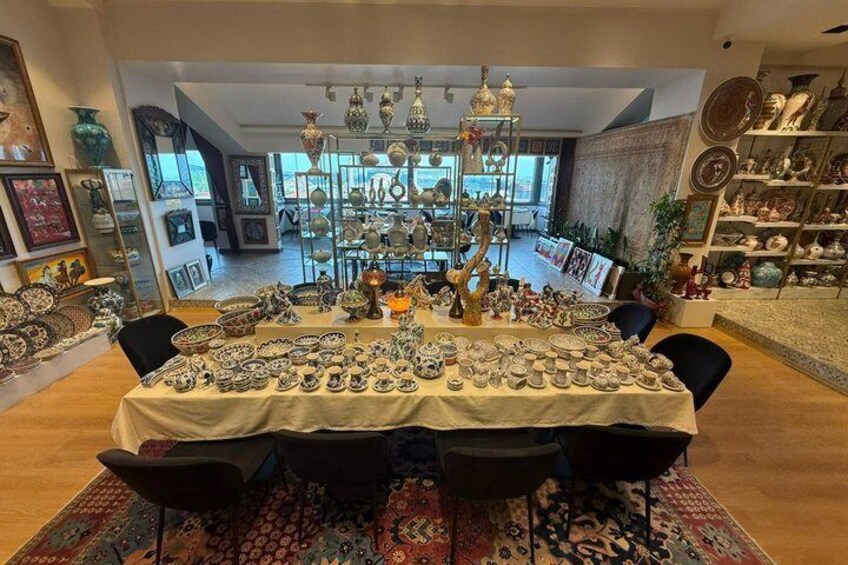 A room with a table covered in ceramic dishes and a patterned rug. 5