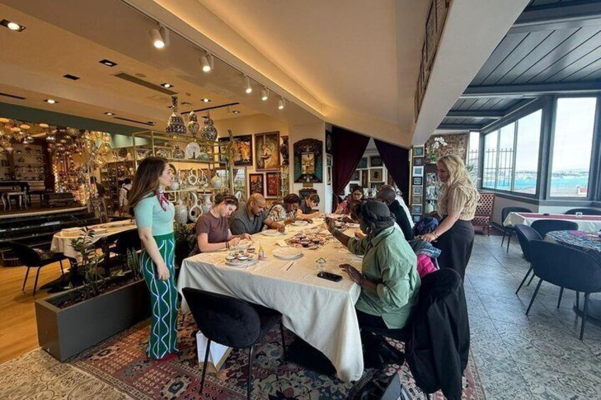 A restaurant with a dining area, tables, chairs, and a view through large windows. 2
