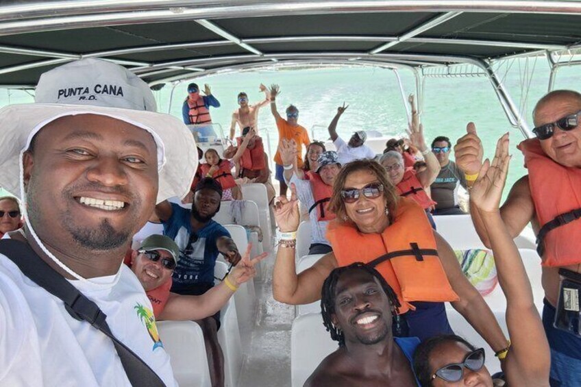 A group of people on a boat wearing life jackets, with some raising their hands in the air. 3