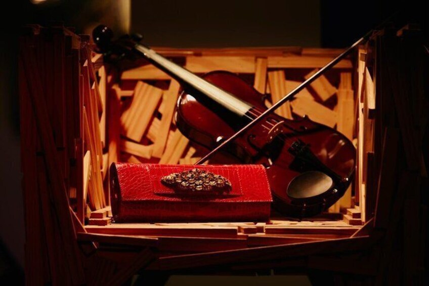 A violin case with a violin inside, placed on a wooden surface. 1