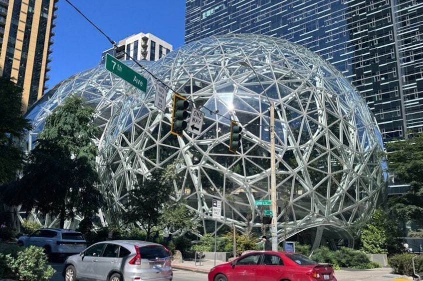A large geodesic dome structure, a street sign for 7th Ave, and a traffic light. 3