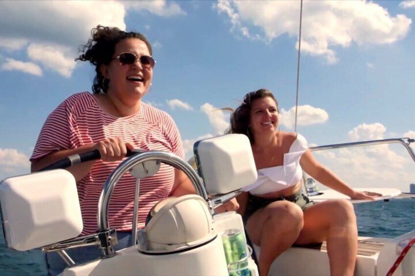 Two people on a boat with a clear sky and water in the background. 1