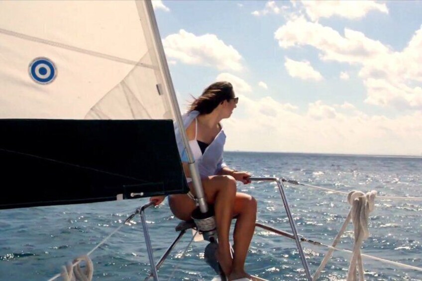A person sailing on a sailboat with a clear sky and calm sea. 5